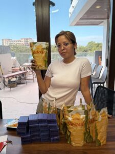 A lady in white top showing Myriad Melonia pouch