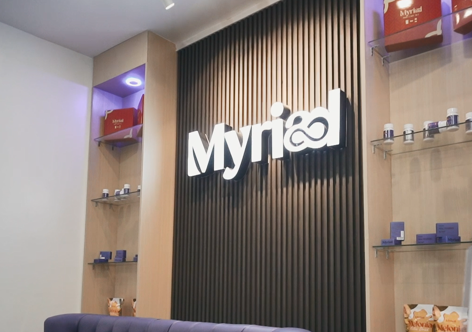 Myriad Logo behind a brown fluted panel